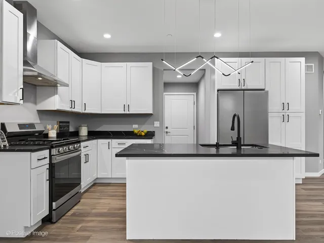 a kitchen with stainless steel appliances granite countertop a refrigerator and a stove