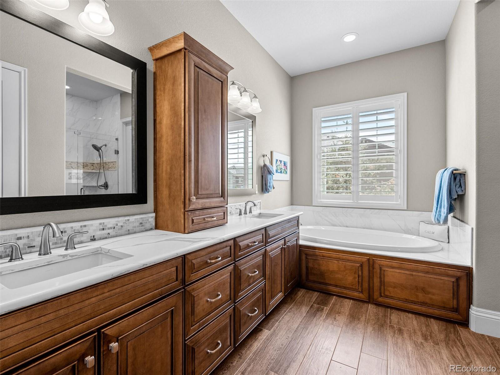 14945 Lyons Ridge Drive Morrison, CO 80465 - Photo 17 of 40 a bathroom with a tub a sink and a large mirror