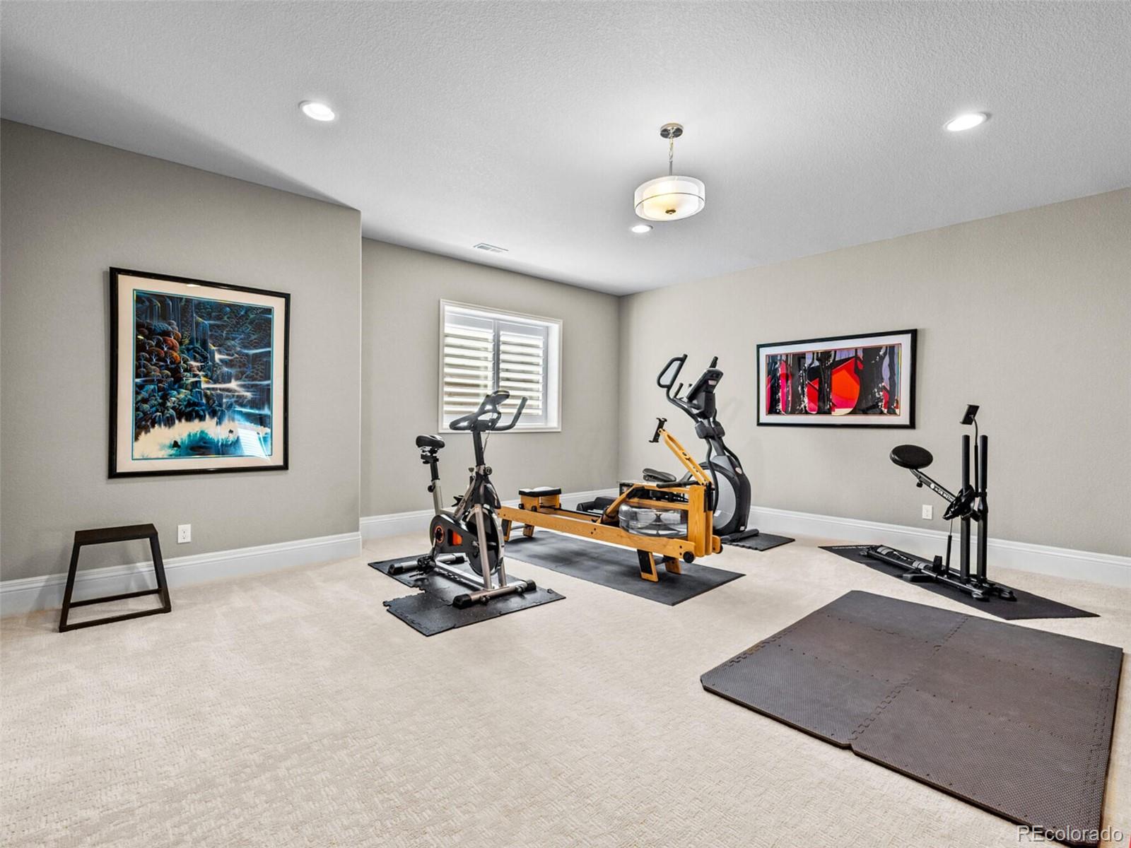 14945 Lyons Ridge Drive Morrison, CO 80465 - Photo 29 of 40 a living room with furniture gym equipment and a chandelier