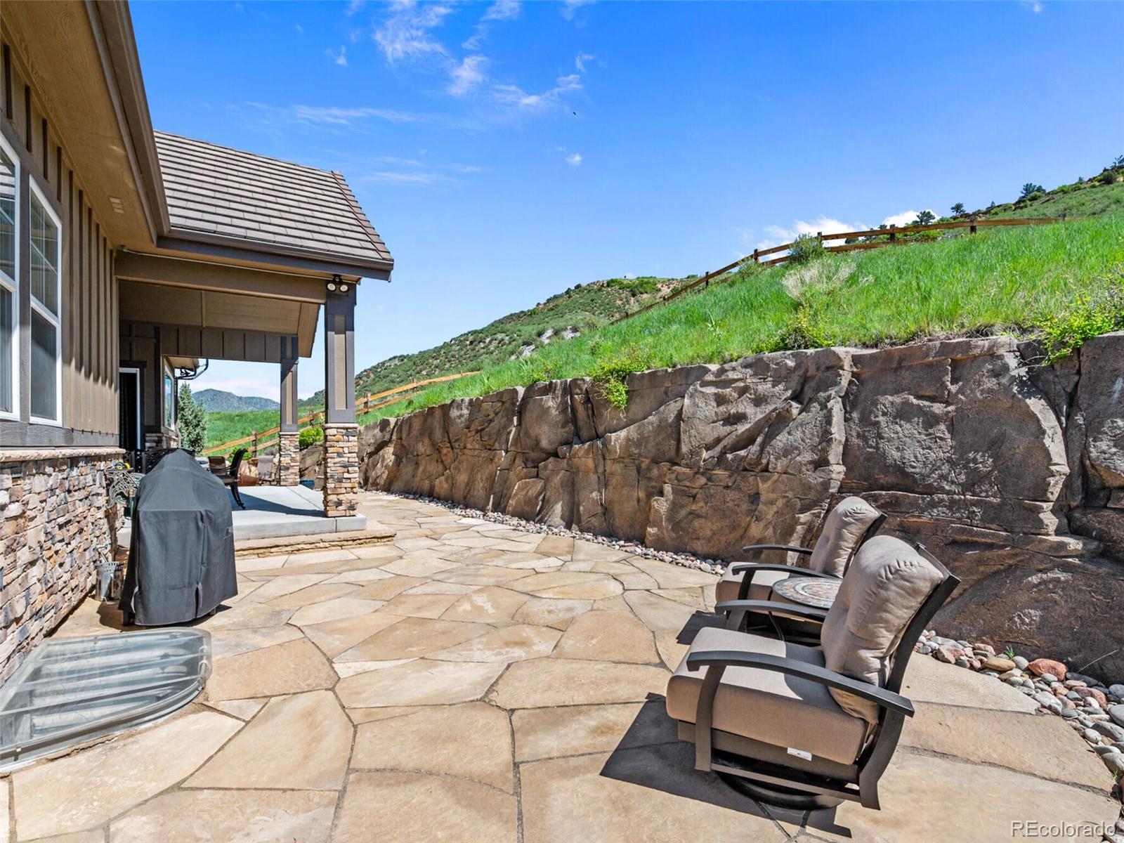 14945 Lyons Ridge Drive Morrison, CO 80465 - Photo 32 of 40 a view of a patio with table and chairs with wooden floor and fence