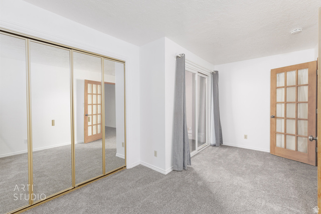 860 South Village Road, Unit A6 St. George, UT 84770 - Photo 7 of 41 Unfurnished bedroom featuring light colored carpet, a closet, and a textured ceiling