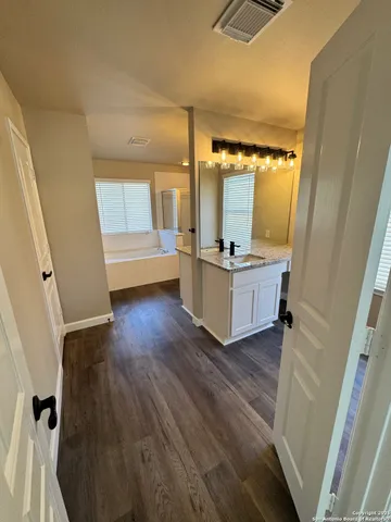 a bathroom with a tub sink and mirror