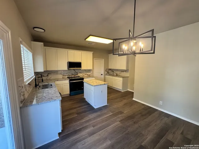 a kitchen with stainless steel appliances a stove a sink dishwasher a microwave oven and a refrigerator