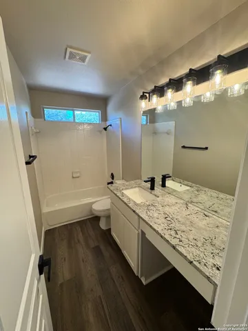 a bathroom with a sink a toilet and mirror