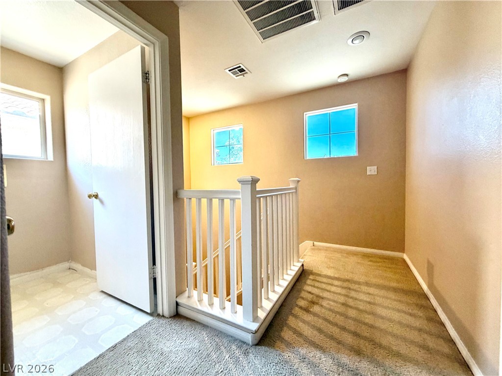 3936 Gold Point Street Las Vegas, NV 89129 - Photo 16 of 23 A well-lit landing and staircase provide natural illumination for the upper level.