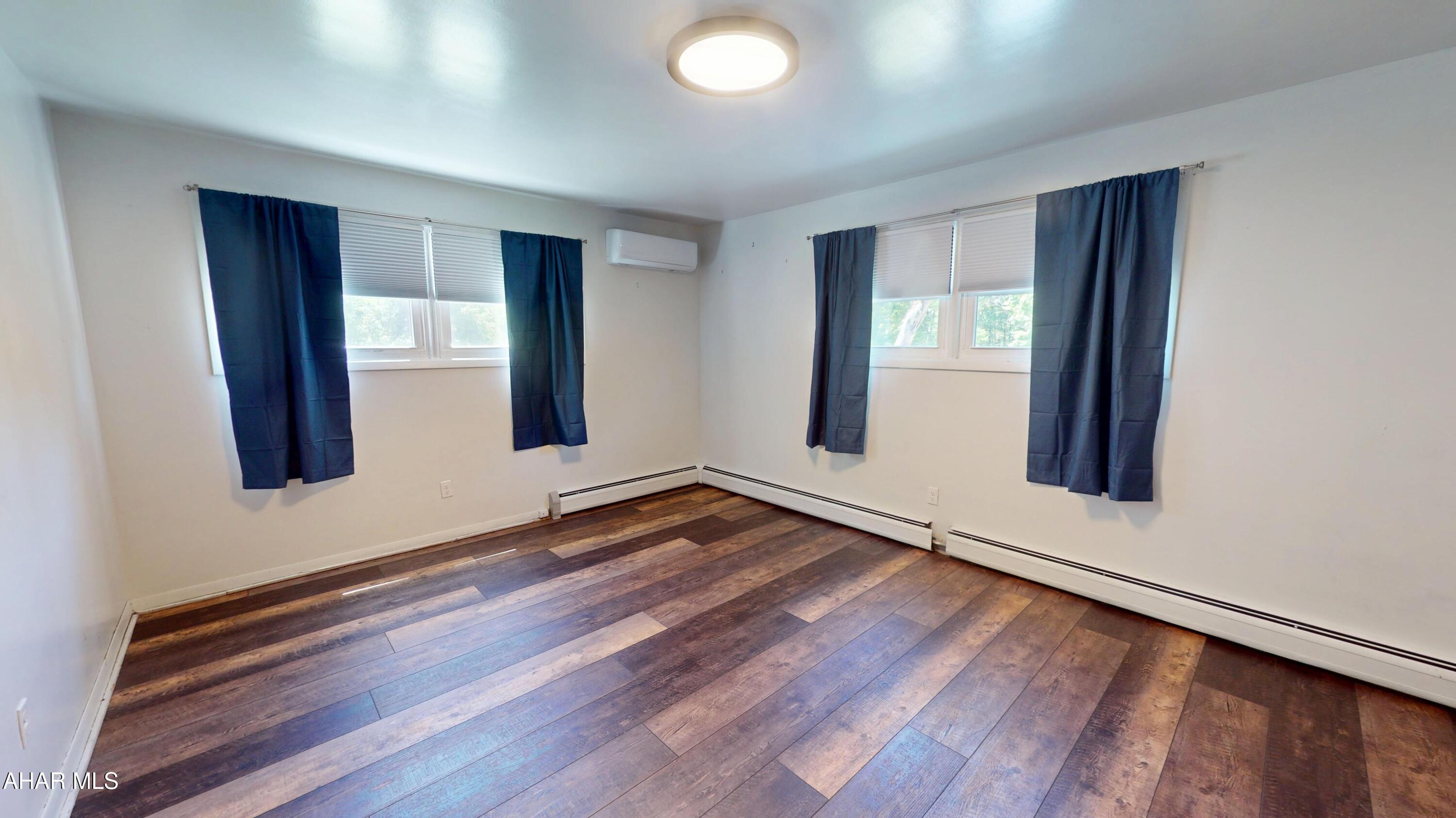 871 Decker Hollow Road Tyrone, PA 16686 - Photo 23 of 35 an empty room with wooden floor and windows