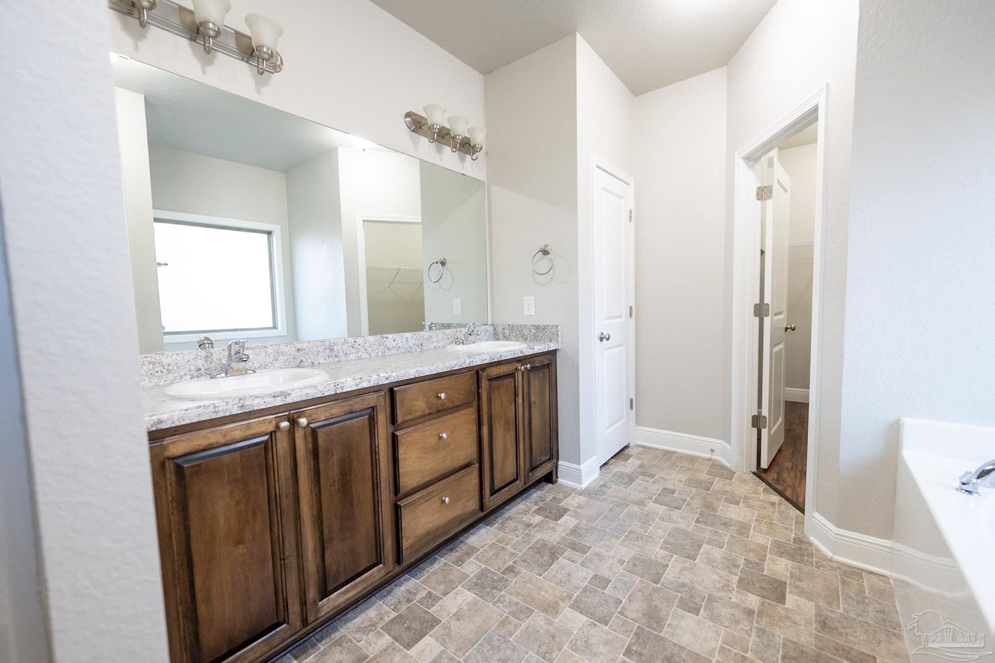 1060 Bretts Way Cantonment, FL 32533 - Photo 15 of 32 a bathroom with a granite countertop sink and a mirror
