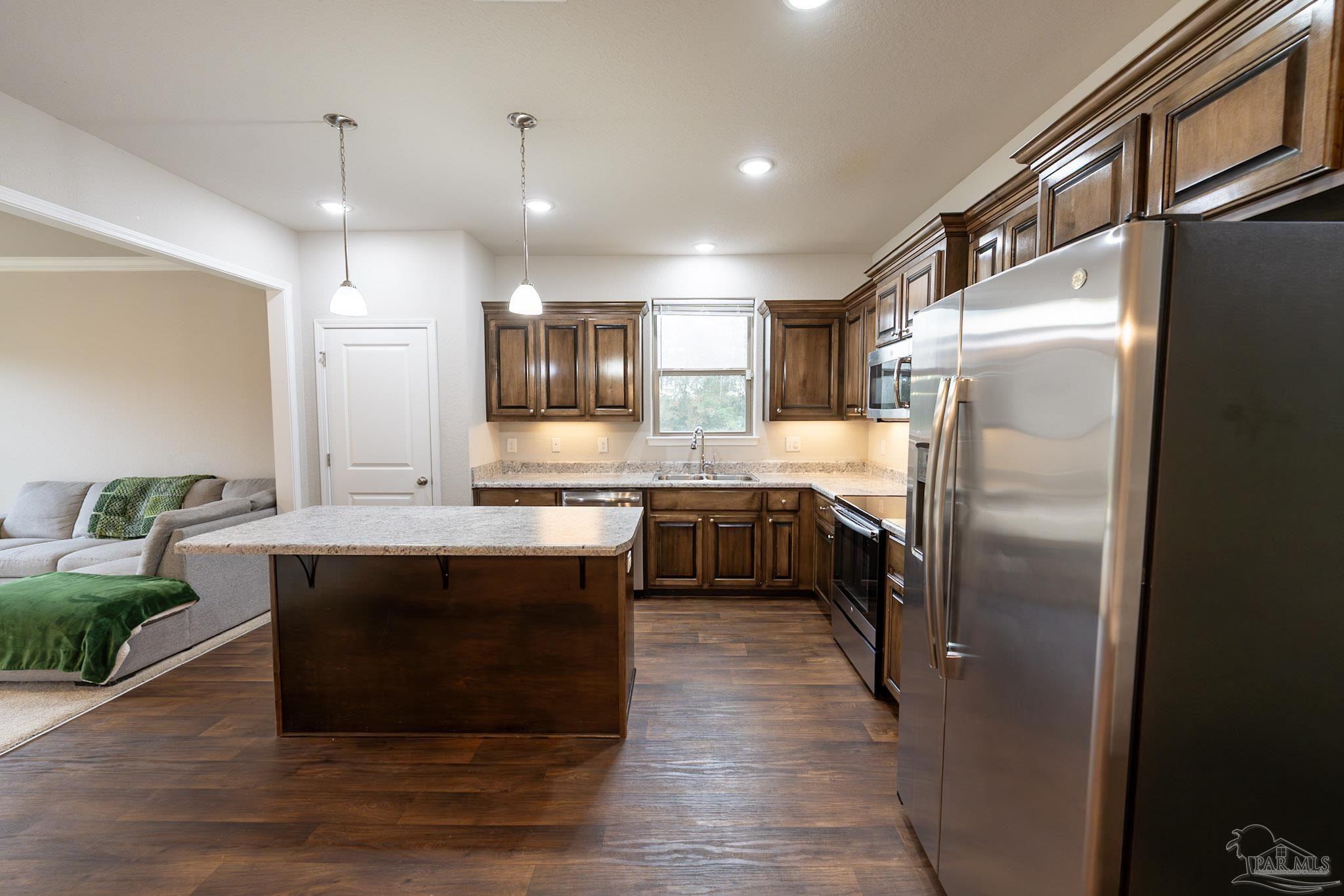 1060 Bretts Way Cantonment, FL 32533 - Photo 4 of 32 a kitchen with kitchen island a counter top space a sink stainless steel appliances and cabinets