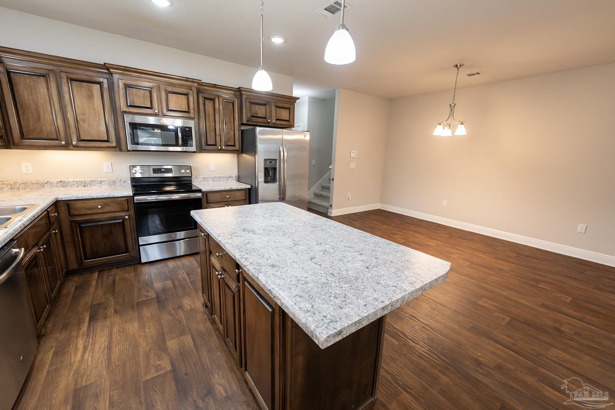 1060 Bretts Way Cantonment, FL 32533 - Photo 7 of 32 a kitchen with stainless steel appliances granite countertop wooden cabinets a stove top oven a sink and dishwasher with wooden floor