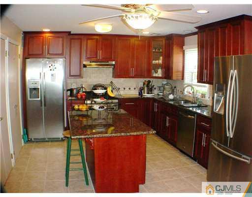 3901 Springbrook Drive Edison, NJ 08820 - Photo 6 of 10 a kitchen with stainless steel appliances kitchen island granite countertop a refrigerator a sink dishwasher with a dining table and chairs