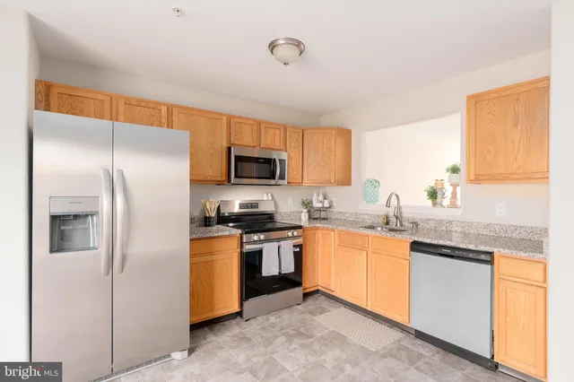 a kitchen with stainless steel appliances granite countertop refrigerator a stove top oven a sink and dishwasher