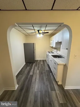 a view of a kitchen with wooden floor and a sink