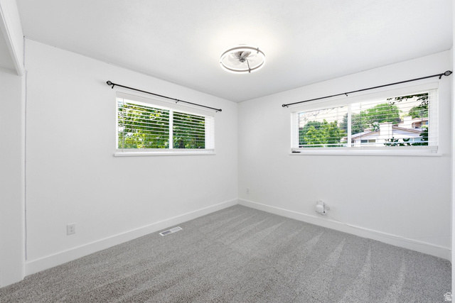 120 North 1230 E Street Springville, UT 84663 - Photo 21 of 60 Bright room featuring two windows with white blinds, neutral gray carpet, white walls, white baseboards, and a contemporary ceiling light fixture