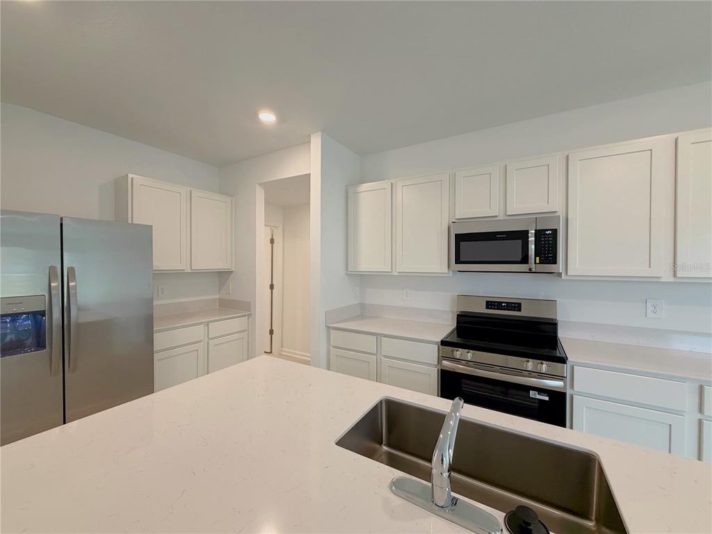 2154 Lasso Loop Eagle Lake, FL 33839 - Photo 6 of 32 a kitchen with stainless steel appliances a refrigerator stove and microwave