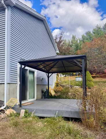 a view of a house with backyard and sitting area