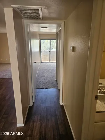 a view of a hallway with wooden floor