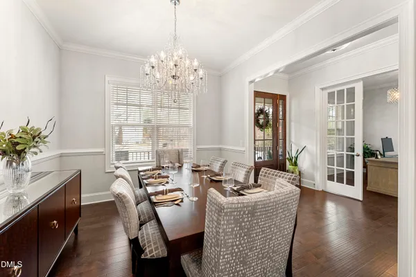 a living room with stainless steel appliances furniture a dining table and chairs