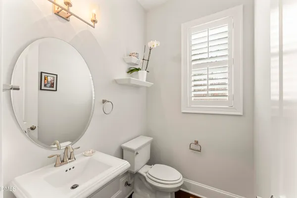 a bathroom with a toilet a sink a mirror and a shower