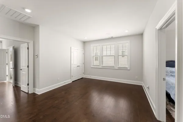 a dining room with wooden floor a chandelier a wooden table and chairs