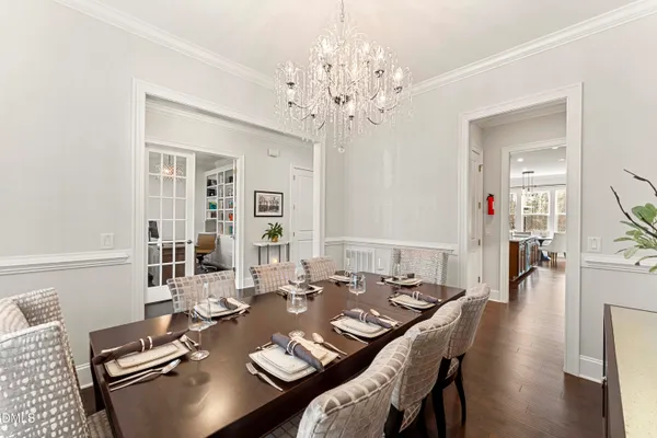 a view of a dining room with furniture a chandelier and wooden floor