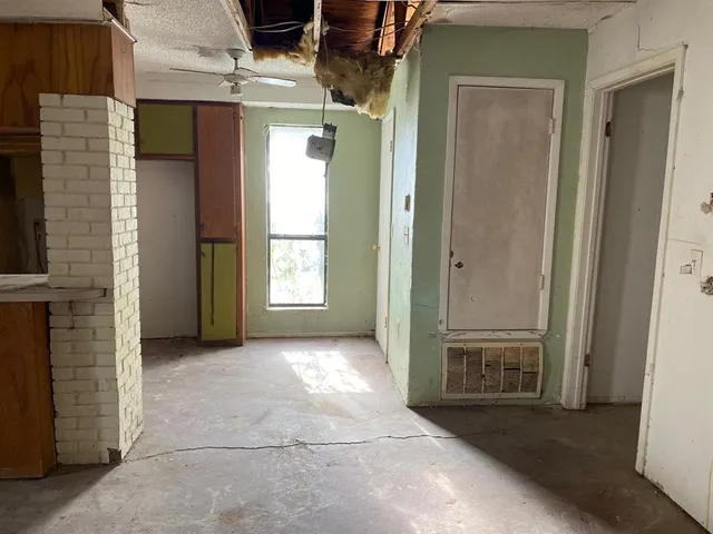 an empty room with windows and closet