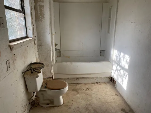 a bathroom with a toilet and a window