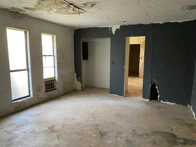 an empty room with windows and closet