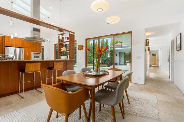 a dining room with furniture and a floor to ceiling window
