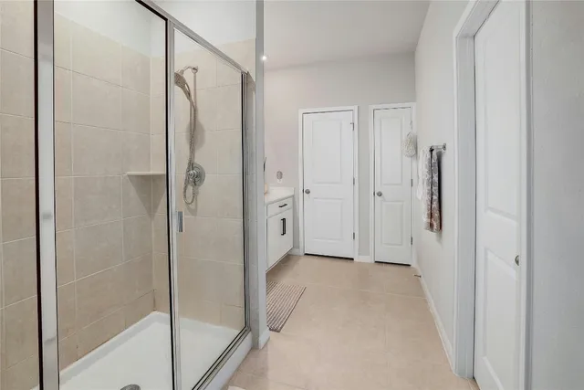 a en suite bathroom with a double vanity sink a mirror and a shower