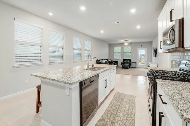 a kitchen with granite countertop a sink and a stove