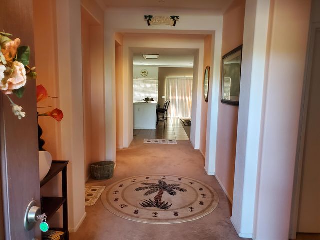a view of a hallway with furniture and floor to ceiling window