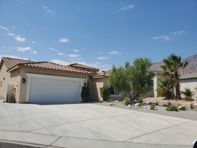 a view of a house with a yard and a garage