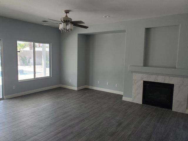 wooden floor fireplace and windows in an empty room