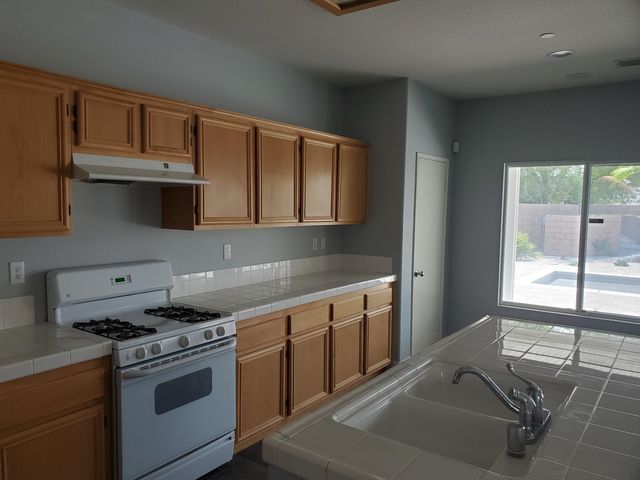 a kitchen with stainless steel appliances granite countertop a stove and a sink