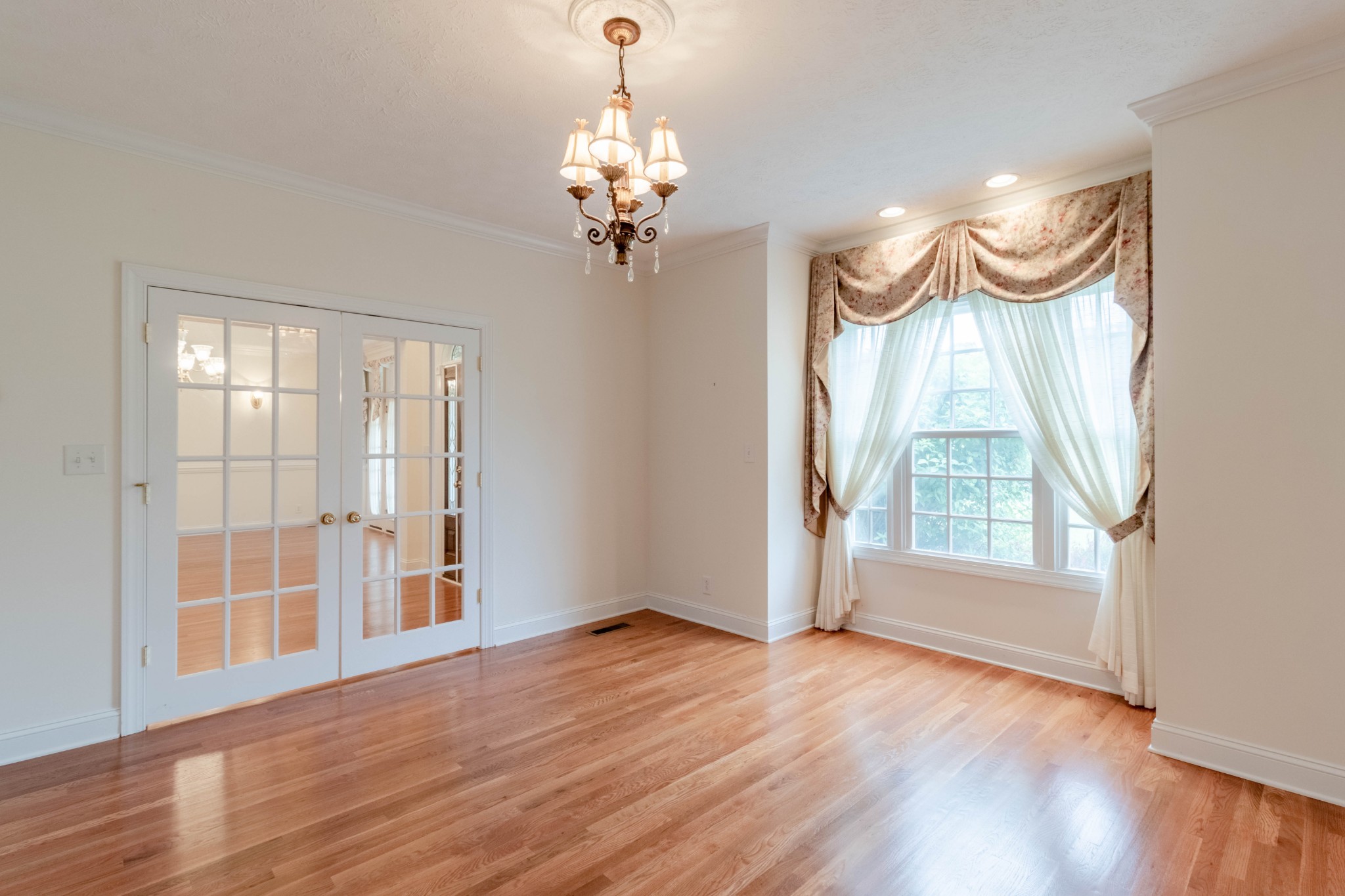 563 Pond Apple Road Clarksville, TN 37043 - Photo 5 of 39 a view of a bedroom with wooden floor and a chandelier