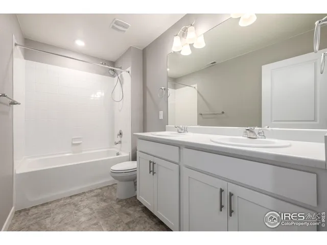 a bathroom with a double vanity sink toilet and a bathtub