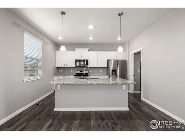 a view of kitchen with stainless steel appliances granite countertop cabinets wooden floor and a window