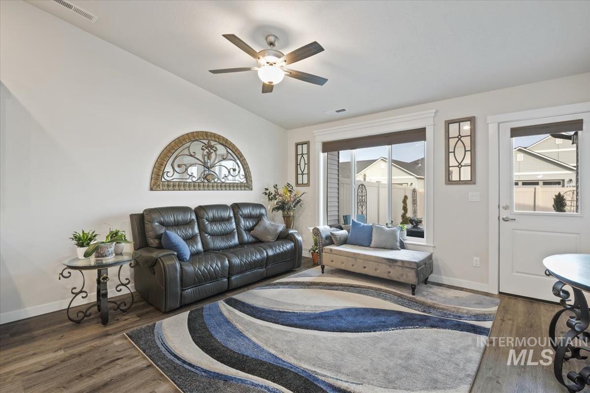 193 West Haniken Street Meridian, ID 83642 - Photo 9 of 27 Living area featuring dark wood-style floors, vaulted ceiling, and a ceiling fan