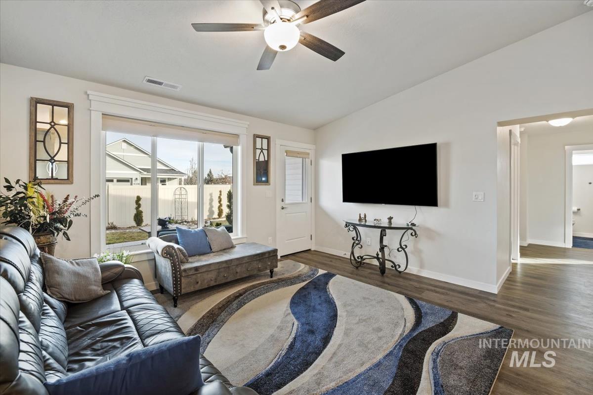 193 West Haniken Street Meridian, ID 83642 - Photo 10 of 27 Living room with a ceiling fan, vaulted ceiling, and dark wood-type flooring