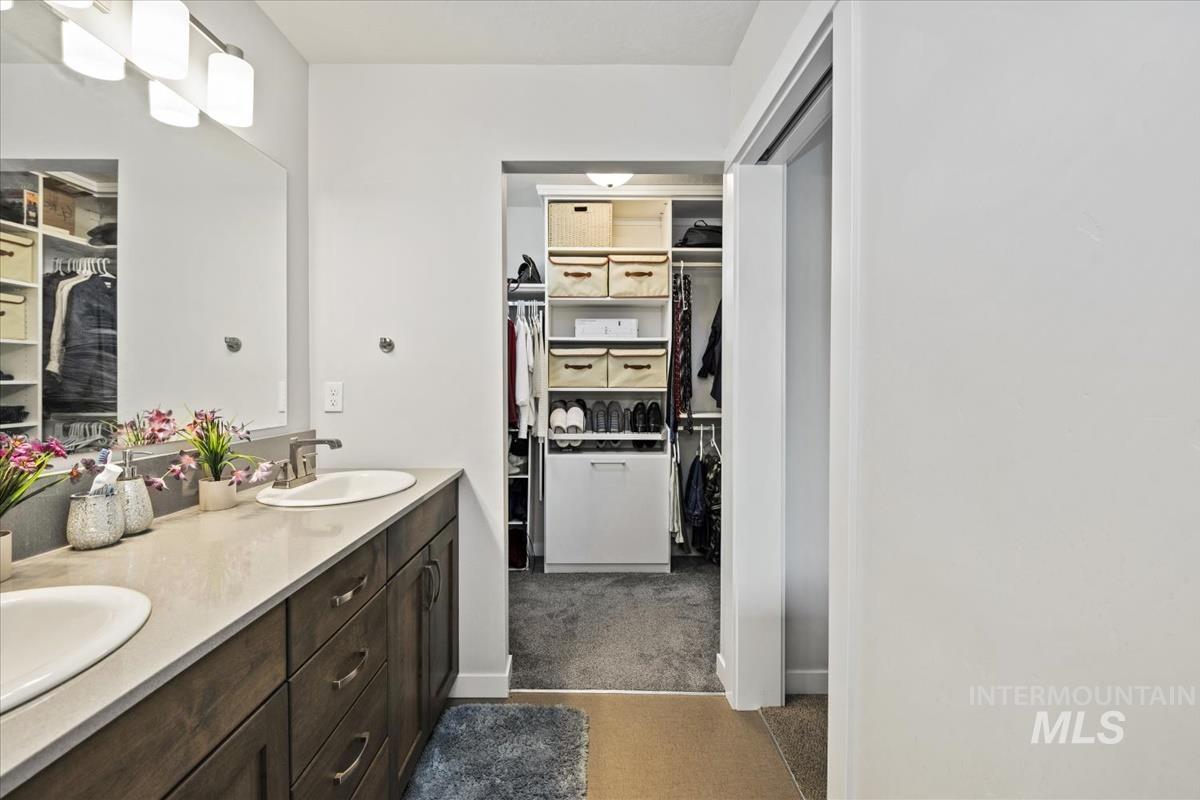 193 West Haniken Street Meridian, ID 83642 - Photo 18 of 27 Full bath featuring a walk in closet, double vanity, and dark colored carpet
