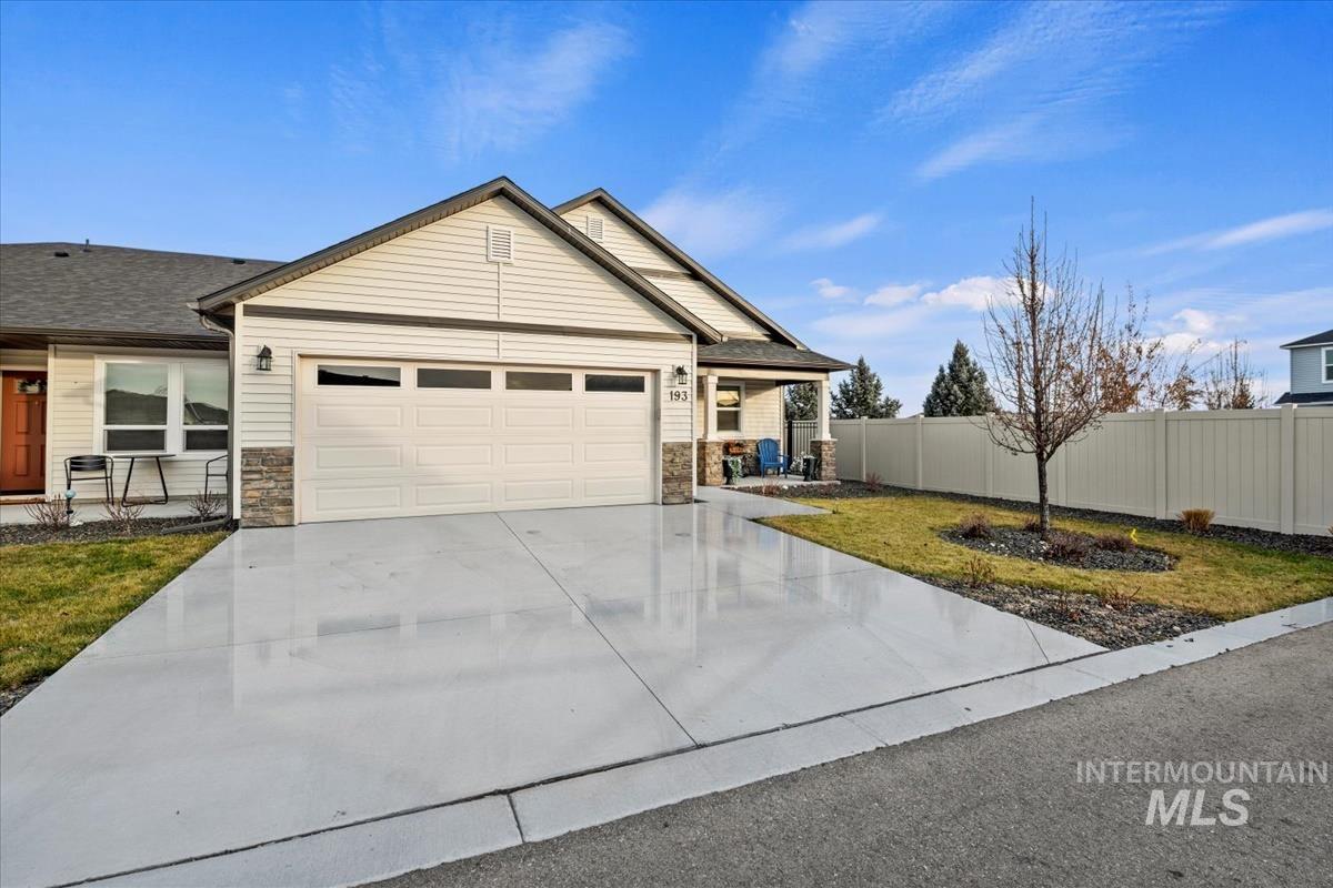 193 West Haniken Street Meridian, ID 83642 - Photo 24 of 27 View of front facade featuring stone siding, concrete driveway, a garage, and roof with shingles