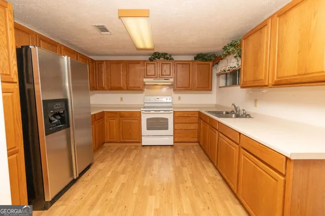 a kitchen with cabinets a sink and stainless steel appliances