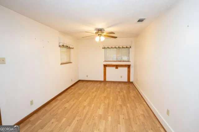 a view of a kitchen with wooden floor and a ceiling fan