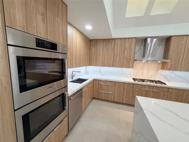 a kitchen with granite countertop cabinets stainless steel appliances and a counter space