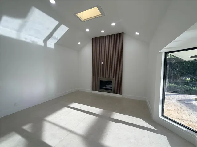 an empty room with windows and fireplace