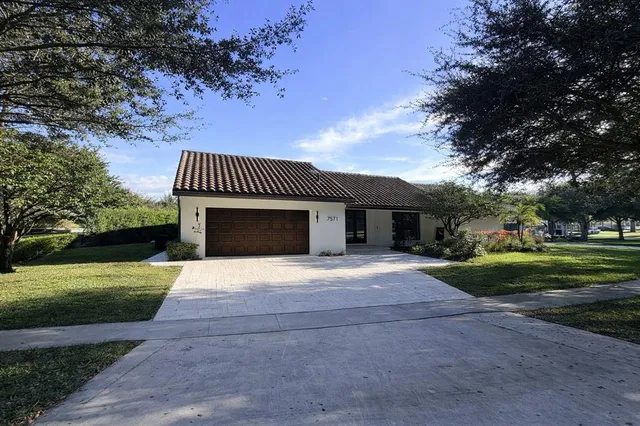 a front view of a house with a yard garage and outdoor seating