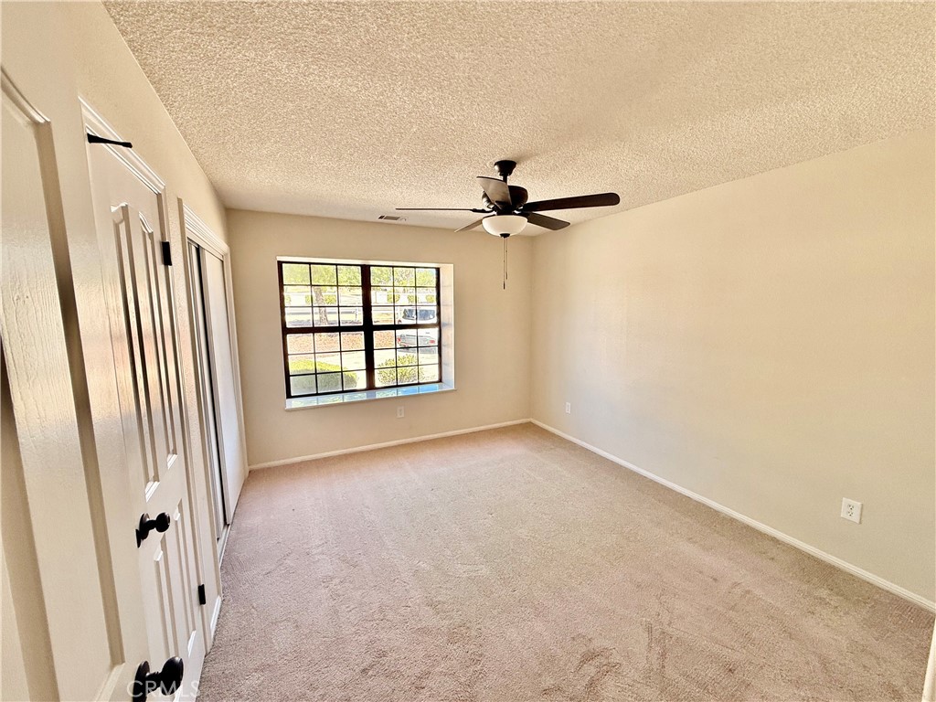 14890 Apple Valley Road Apple Valley, CA 92307 - Photo 12 of 28 an empty room with windows and fan