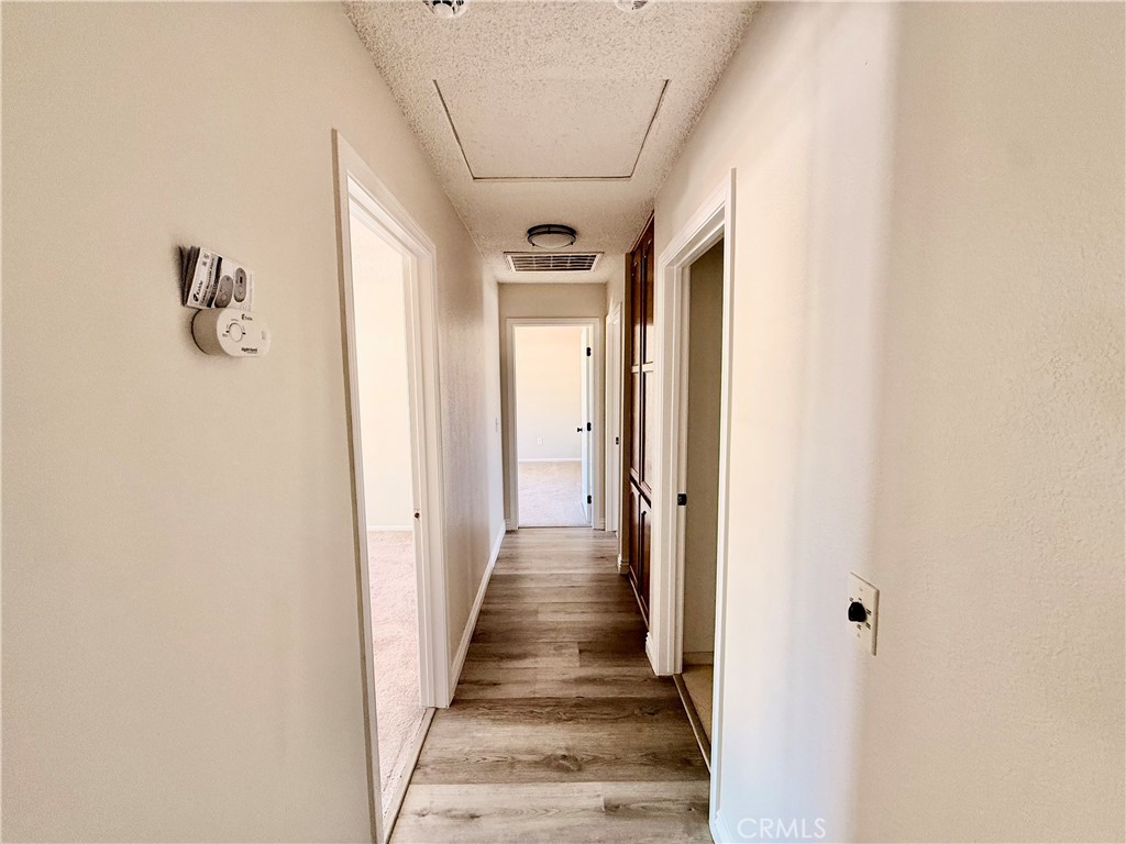 14890 Apple Valley Road Apple Valley, CA 92307 - Photo 18 of 28 a view of a hallway with wooden floor and entryway