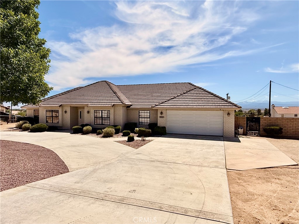 14890 Apple Valley Road Apple Valley, CA 92307 - Photo 28 of 28 a front view of a house with a yard and garage