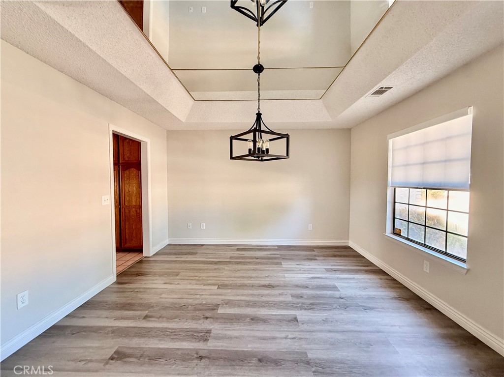 14890 Apple Valley Road Apple Valley, CA 92307 - Photo 3 of 28 a view of a room with wooden floor and windows